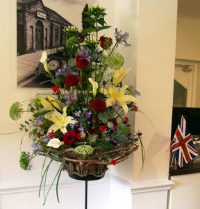 Beautiful standing flower arrangement of red roses, white lilies and foliage for HRH Prince of Wales visit to Morgan Cars